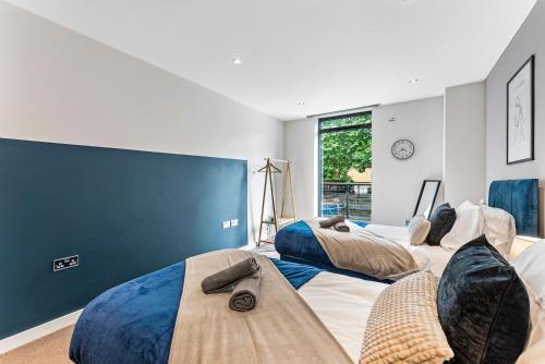 two beds in a room with a blue wall at Designer Apt in Central Lincoln - Sleeps 8 in Lincoln