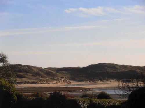 a view of a beach with hills in the background at Maison charmante à Portbail avec jardin et vue mer in Portbail