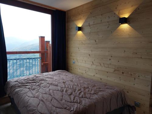 - une chambre avec un mur en bois, un lit et une fenêtre dans l'établissement Appartement cosy 2 pièces, 6 pers, proche pistes et commerces - Wifi - Parking - FR-1-411-174, à Arc 1800