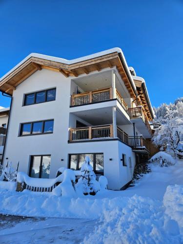 a house with snow on the ground in front of it at Appartements Wolfgang Auderer in Jerzens