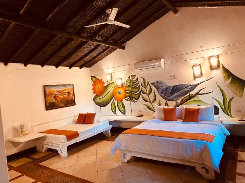 Hotel Portón del Sol في سانتا في دي أنتيوكيا: غرفة نوم بسريرين ولوحة على الحائط