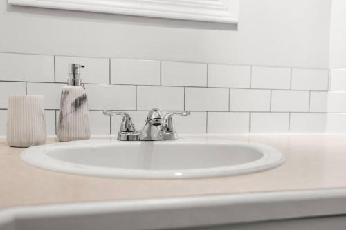 a white bathroom sink with a soap dispenser on it at Mountain Retreat in North Saanich