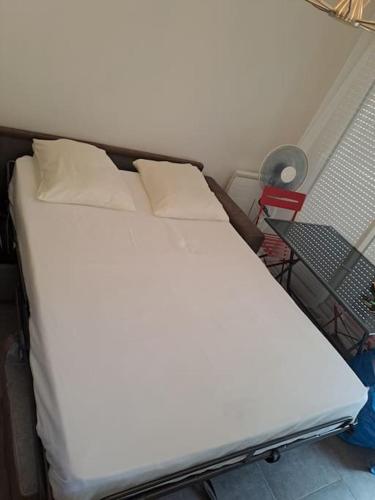 - un lit blanc avec 2 oreillers dans l'établissement Barcarès - Studio à 50 m plage dans Village, au Barcarès