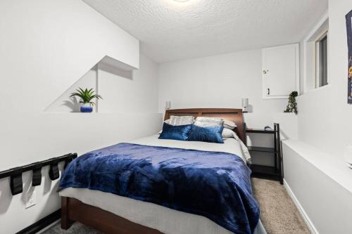 a bedroom with a bed with a blue comforter at Mountain Retreat in North Saanich