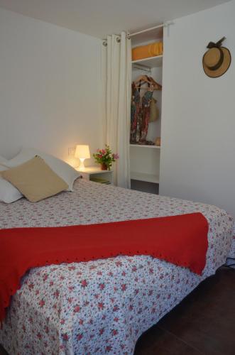 a bedroom with a bed with a red blanket at Apartment Rovellada Platja in Colera