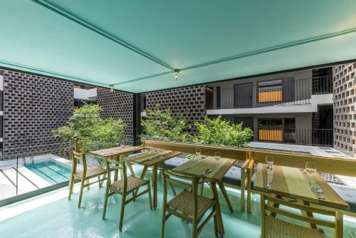 un patio avec une table et des chaises et une piscine dans l'établissement Hotel Carlota, à Mexico