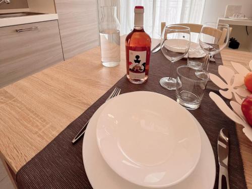 a table with a white plate and a bottle of wine at Donna Anna in Polignano a Mare