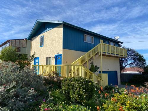 a large house with blue doors and a balcony at Harbor House in Morro Bay in Morro Bay