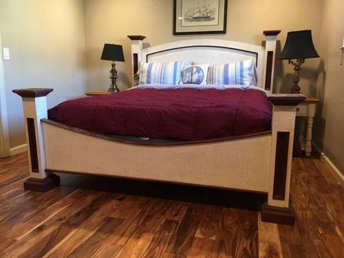 a large bed in a bedroom with a wooden floor at Harbor House in Morro Bay in Morro Bay