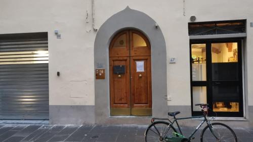 een fiets geparkeerd voor een gebouw met een houten deur bij UNYCA - Art of Florence Apartment in Florence
