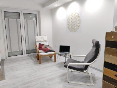 soggiorno con sedia e scrivania con computer portatile di Casa Akira a Riva del Garda