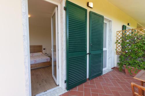 a door leading to a room with green shutters at I 7 MELI in Sarzana