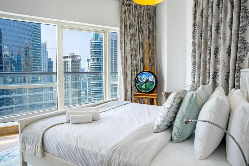 a bedroom with a bed with a large window at Veluxa - Stylish 2 Bed with View in Dubai
