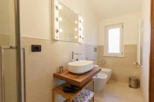 a bathroom with a sink and a toilet and a mirror at I 7 MELI in Sarzana