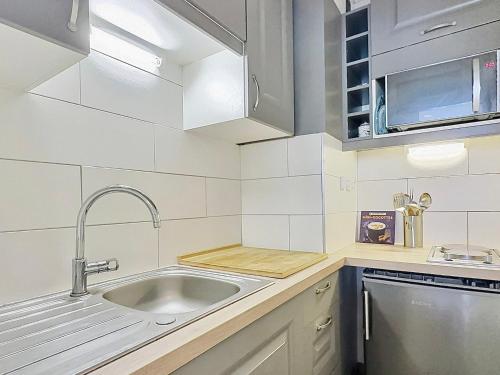 Il comprend une petite cuisine équipée d'un évier et d'un lave-vaisselle. dans l'établissement Studio skis aux pieds pour 4, proche commerces et balcon sud à Tignes - FR-1-411-440, à Tignes