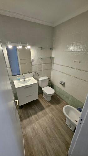 a bathroom with two toilets and a sink and a mirror at Bungalows Los Melocotones in Maspalomas