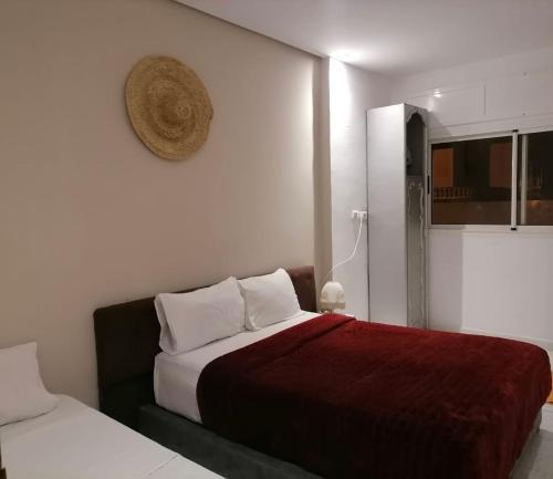 ein Schlafzimmer mit 2 Betten und einem Hut an der Wand in der Unterkunft Cozy vintage styl bedroom family only in Tangier
