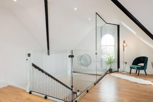 eine Glastreppe mit einem Stuhl und einem Spiegel in der Unterkunft Spacious & Modern Two Bedroom Apartment in Catford, London in Catford