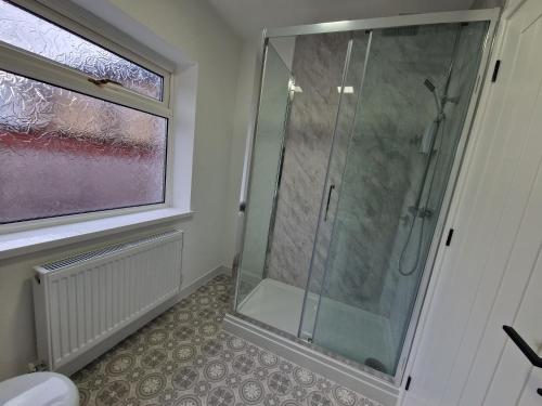 a shower stall in a bathroom with a window at 3 bedroom Urban Retreat Near Bike Park Wales in Merthyr Tydfil