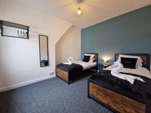 a bedroom with two beds with white animals on them at 3 bedroom Urban Retreat Near Bike Park Wales in Merthyr Tydfil
