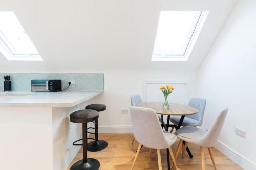 a kitchen and dining room with a table and chairs at Spacious & Modern Two Bedroom Apartment in Catford, London in Catford