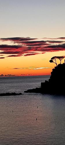 a sunset over a body of water with a beach at La casa dei Paggi in Sestri Levante