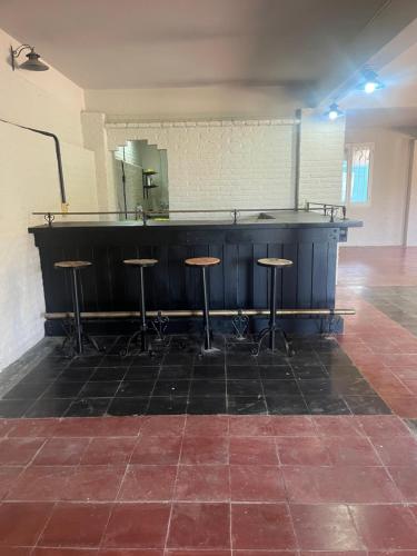 un bar con taburetes en una habitación con espejo en La casa de la Quebrada en San Lorenzo