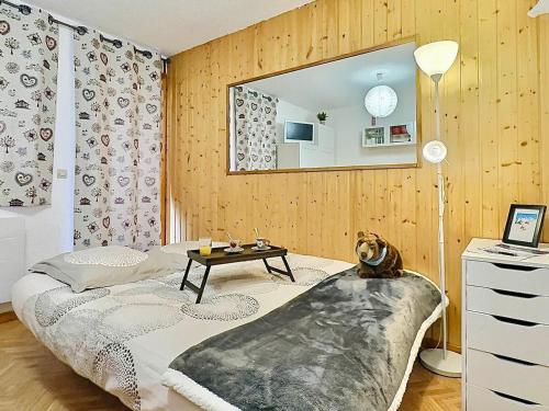 Cette chambre comprend un lit avec une table et un miroir. dans l'établissement Studio cabine 4 pers à Tignes, pied des pistes, proche commerces, balcon au sud, bien équipé - FR-1-411-486, à Tignes