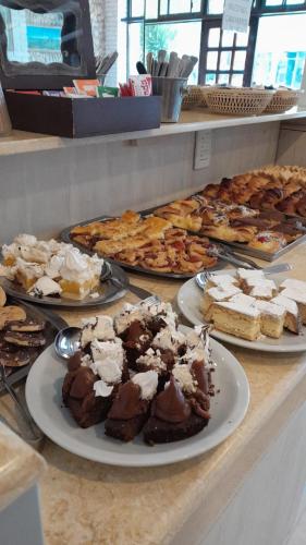 un buffet con varios platos de postres en un mostrador en Hotel Bertiami, en Mar del Plata