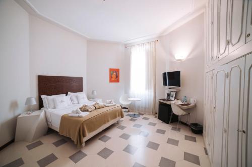 a bedroom with a bed and a desk and a television at B&B Barone Liberty & Luxury SPA in Gallipoli
