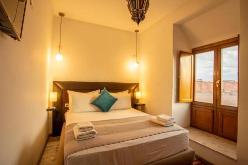 a bedroom with a bed with two towels on it at Riad Kenza in Marrakech
