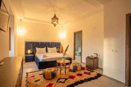 a bedroom with a bed and a table and a rug at Riad Kenza in Marrakech
