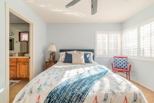 a bedroom with a bed and a red chair at Bayfront Dream - Bay Views, Rooftop Patio, & Garage! in San Diego
