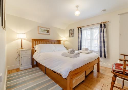 a bedroom with a large bed with towels on it at Wayfarer Cottage in Woodbridge