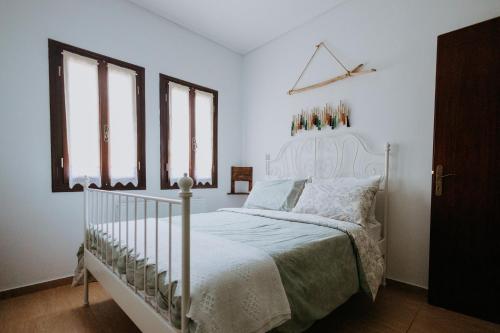 sypialnia z białym łóżkiem i oknami w obiekcie Villa Andromeda Pelion w mieście Portariá