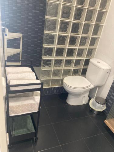 a bathroom with a toilet and a glass wall at Apartamento Edificio Lirios Politur in Platja  d'Aro