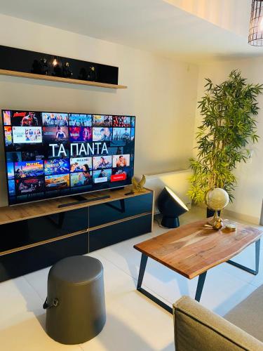 a living room with a tv and a coffee table at NEW 2BD APRT with SHARED ROOFTOP POOL E2 in Athens