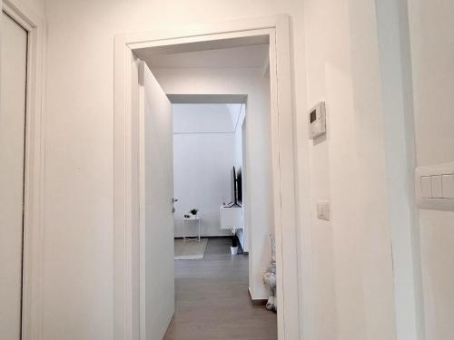 einen Flur mit weißen Wänden und einer offenen Tür in der Unterkunft Donna Anna in Polignano a Mare