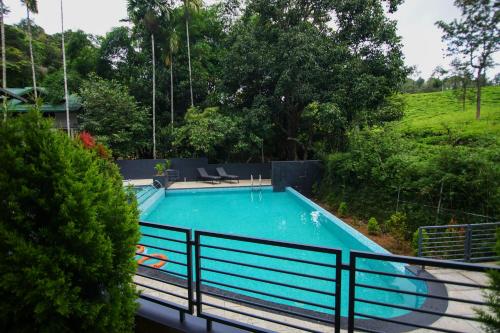 a swimming pool in a yard with a fence at B'camp Resorts & Homestays in Wayanad