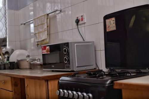 un forno a microonde seduto sopra un bancone della cucina di The Carina Homes a Kisumu