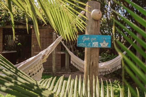a sign on a pole with a hammock and a house at Pousada Vila Campeche in Florianópolis
