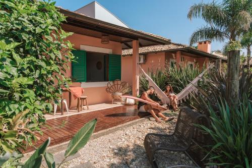 two women sitting on the porch of a house at Pousada Vila Campeche in Florianópolis