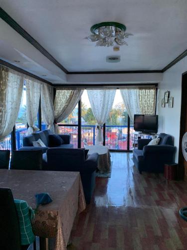 a living room with blue couches and a tv at 2 BD, 2BR Condo Rental,Toril in Davao City