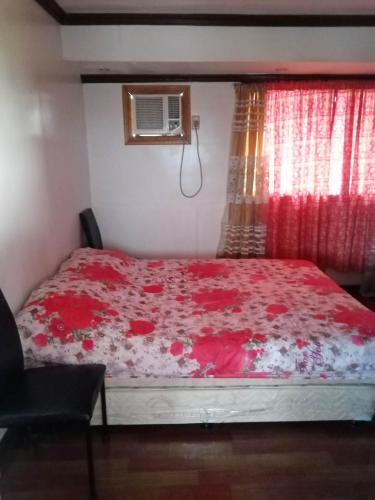 ein Schlafzimmer mit einem roten Bett mit einem roten Vorhang in der Unterkunft 2 BD, 2BR Condo Rental,Toril in Davao City