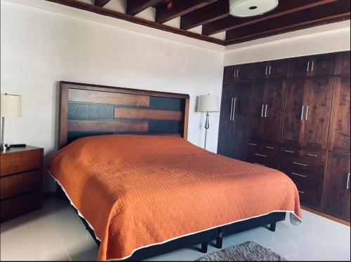 een slaapkamer met een groot bed en houten kasten bij Casa Terrazas Gardel in Guanajuato