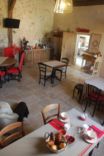 une cuisine et une salle à manger avec tables et chaises dans l'établissement Ferme du Grand Hotel du Bois, à Jouarre
