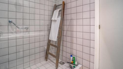 - une salle de bains carrelée de blanc avec une échelle dans la douche dans l'établissement El Far, à Begur