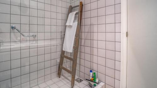 a white tiled bathroom with a ladder in the shower at Cap Sa Sal 160 Begur in Begur