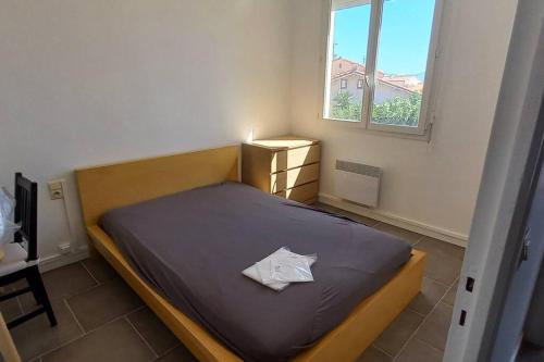 une chambre avec un lit avec un oreiller dessus dans l'établissement Barcarès village - plage - mer - 4/9p+cour 3 étoil, au Barcarès