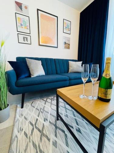 a living room with a blue couch and two wine glasses at Apartmán Twins Blue blízko centra in Michalovce